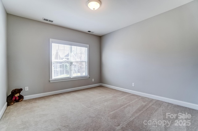 empty room with carpet floors, baseboards, and visible vents