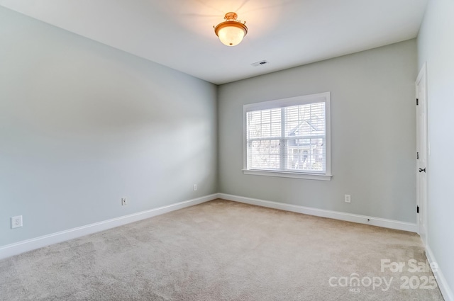 carpeted empty room featuring visible vents and baseboards