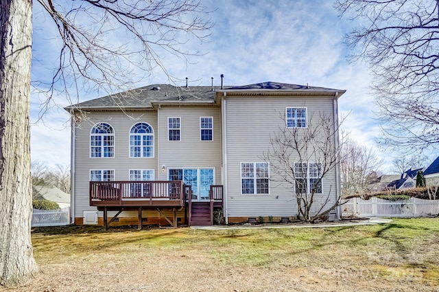 rear view of property featuring a yard, fence, and a wooden deck