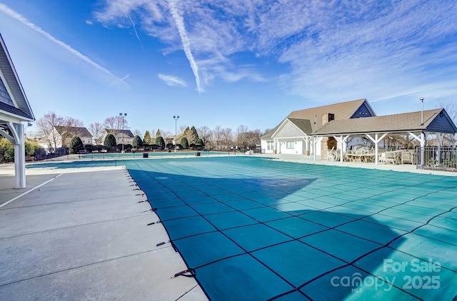 pool with fence and a patio