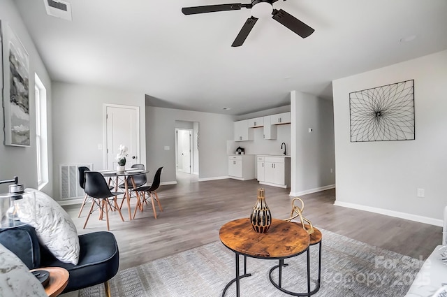 living area featuring dark wood-type flooring, visible vents, and baseboards