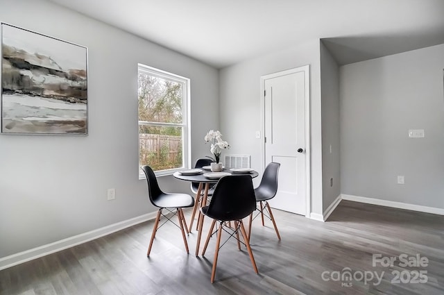 dining room with visible vents, baseboards, and wood finished floors