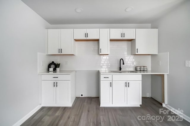 kitchen with tasteful backsplash, dark wood-style flooring, white cabinets, and a sink