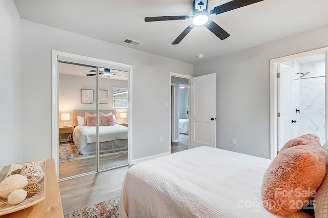 bedroom with a closet, visible vents, ceiling fan, and wood finished floors