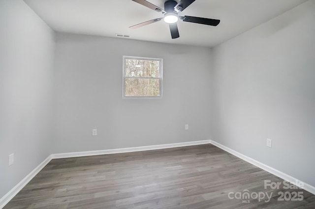 unfurnished room with baseboards, visible vents, ceiling fan, and wood finished floors