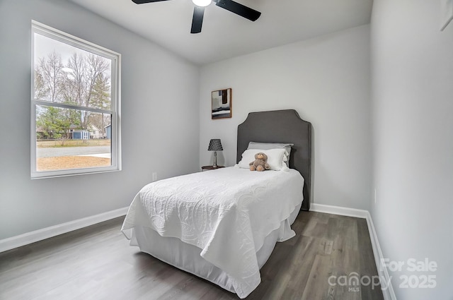 bedroom featuring ceiling fan, baseboards, and wood finished floors