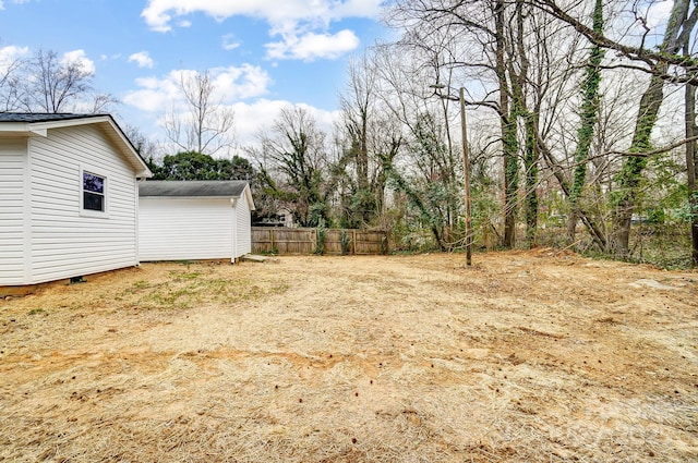 view of yard featuring driveway and fence