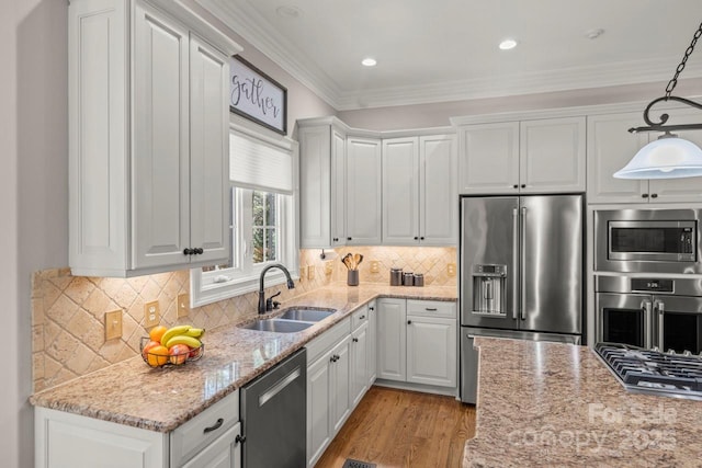 kitchen featuring light wood-style flooring, stainless steel appliances, crown molding, white cabinetry, and a sink