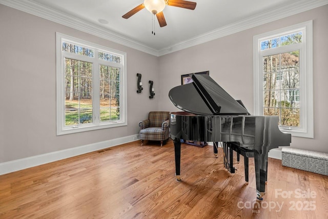 sitting room with a wealth of natural light, crown molding, and wood finished floors