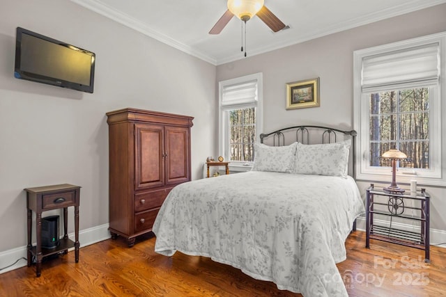 bedroom featuring baseboards, wood finished floors, and ornamental molding