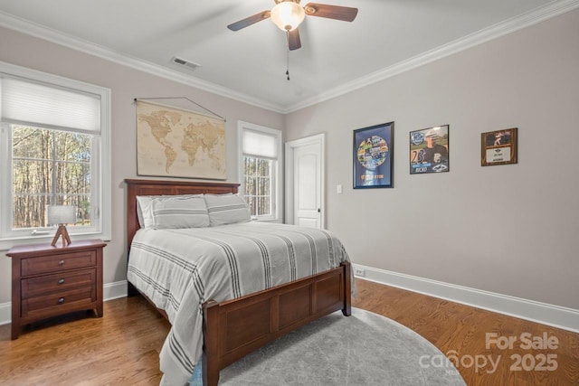 bedroom featuring baseboards, visible vents, and wood finished floors