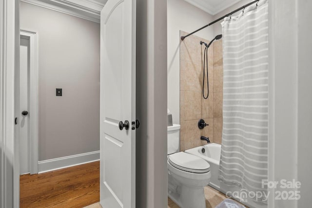 bathroom with baseboards, toilet, wood finished floors, shower / bath combo with shower curtain, and crown molding