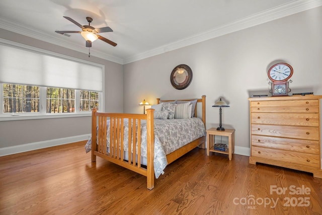 bedroom featuring ornamental molding, a ceiling fan, baseboards, and wood finished floors