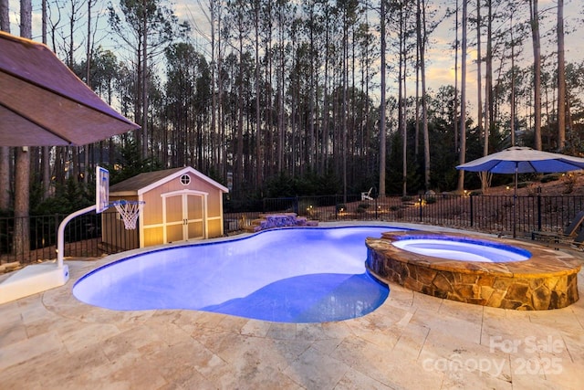 view of swimming pool featuring a patio, a storage unit, fence, an outdoor structure, and a pool with connected hot tub