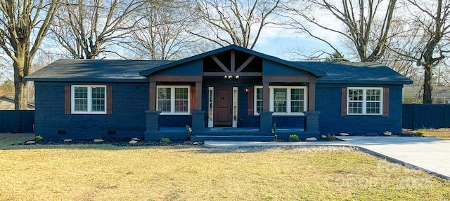 view of front of house with brick siding, crawl space, covered porch, fence, and a front yard