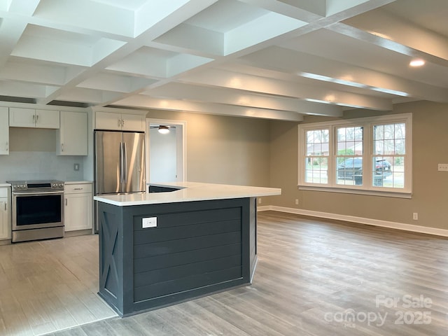 kitchen featuring baseboards, stainless steel appliances, light countertops, and white cabinets