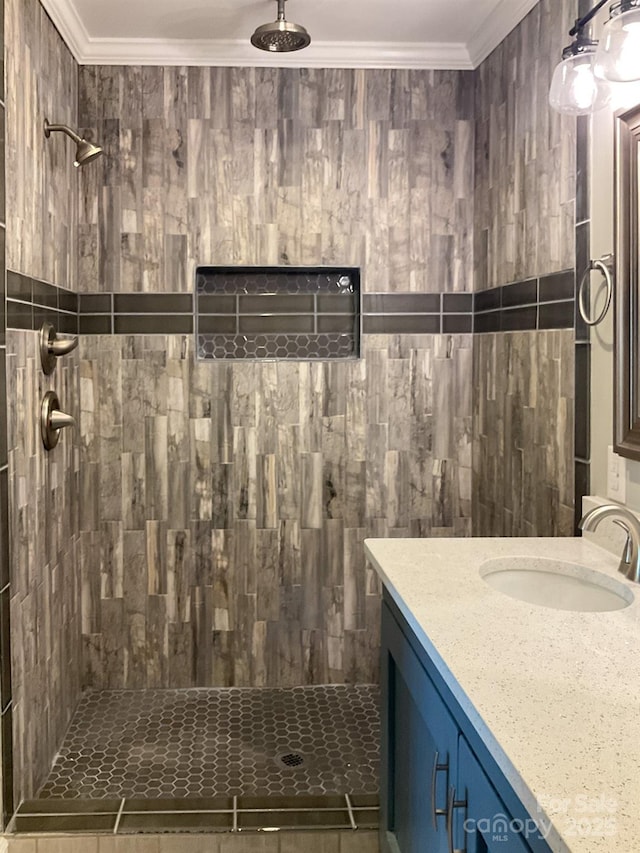 bathroom with a tile shower, vanity, and crown molding