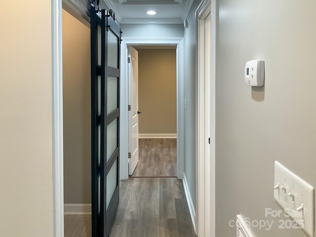 corridor featuring baseboards, wood finished floors, and ornamental molding