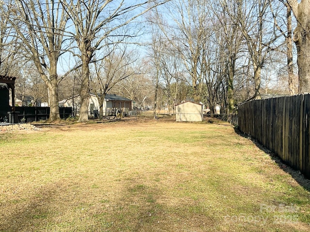 view of yard with fence and an outbuilding