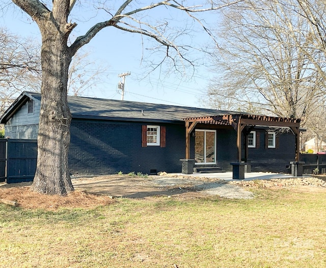 view of front facade with brick siding, fence, crawl space, a pergola, and a front yard