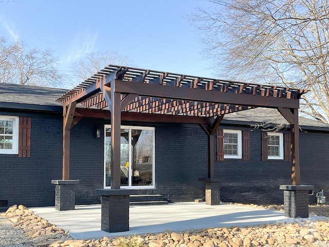 view of front of house with brick siding, crawl space, a patio area, and a pergola