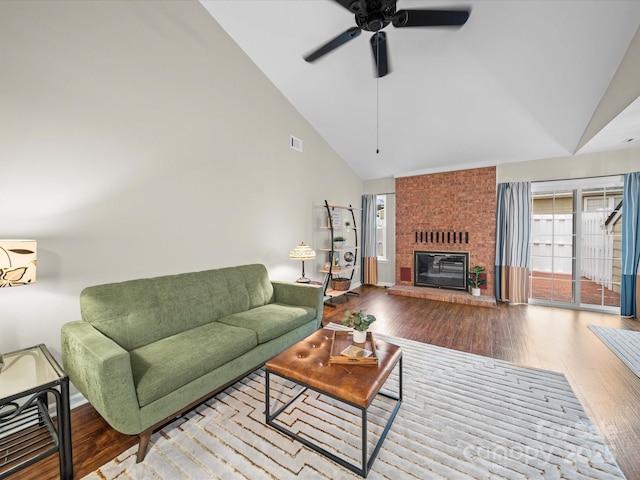 living area featuring visible vents, a fireplace, and wood finished floors