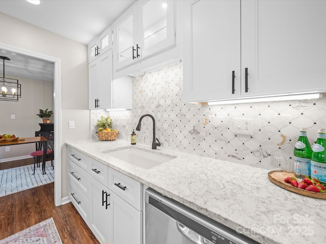 kitchen featuring a sink, light stone countertops, dark wood finished floors, white cabinetry, and stainless steel dishwasher