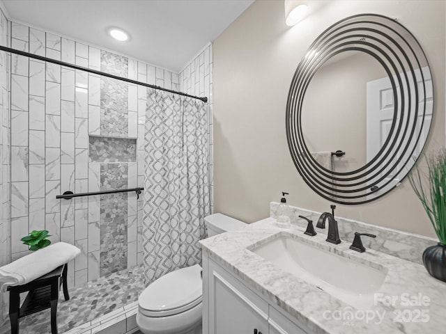 full bathroom featuring toilet, a stall shower, and vanity