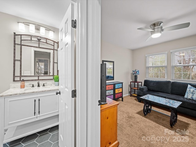 living area featuring dark carpet, baseboards, and ceiling fan