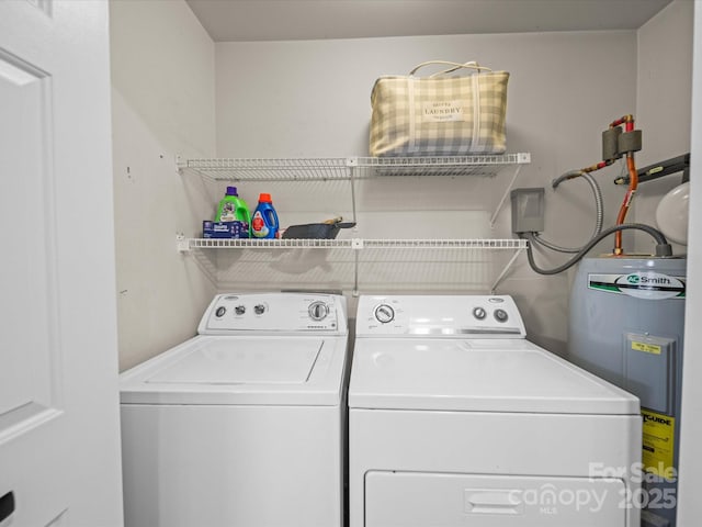 washroom featuring laundry area, electric water heater, and washing machine and clothes dryer