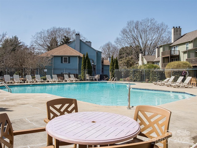 community pool with fence and a patio