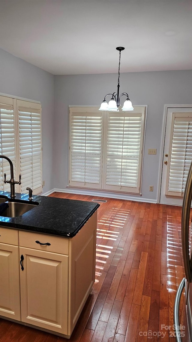 kitchen featuring a chandelier, a sink, a wealth of natural light, hardwood / wood-style floors, and decorative light fixtures