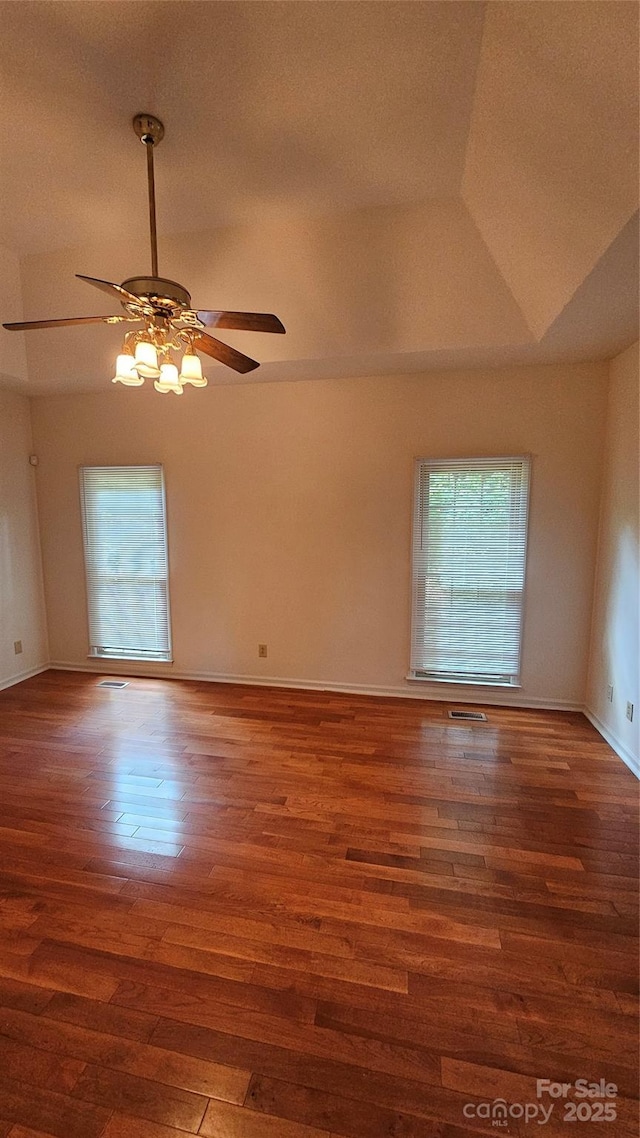 unfurnished room featuring lofted ceiling, ceiling fan, baseboards, and wood finished floors