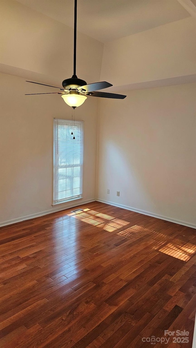 empty room featuring baseboards, a ceiling fan, and hardwood / wood-style floors