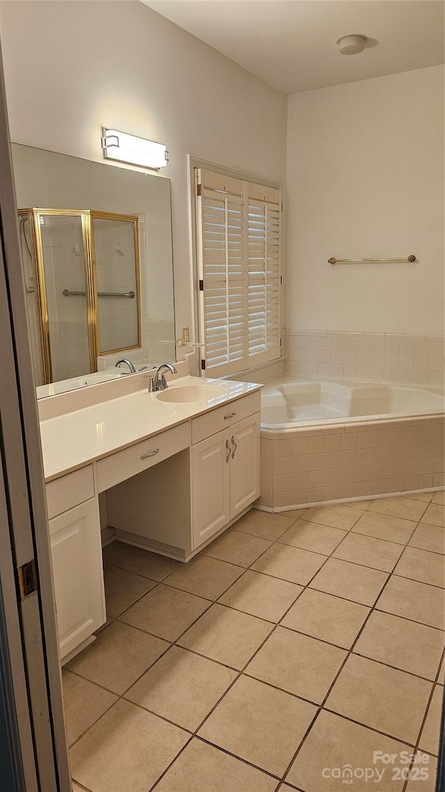 bathroom featuring a stall shower, tile patterned flooring, a garden tub, and vanity