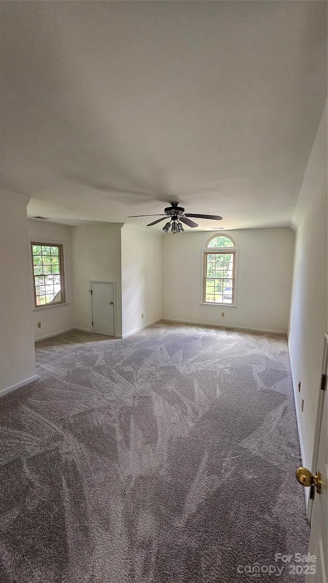 spare room with ceiling fan, carpet floors, and baseboards