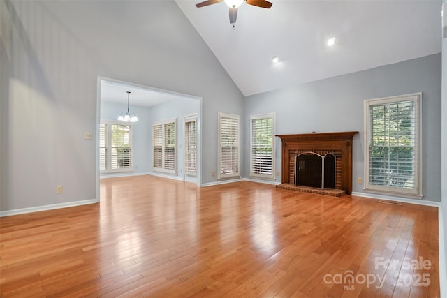 8731 Sheltonham Way, Charlotte, NC 28216 - unfurnished living room featuring high vaulted ceiling, light wood-type flooring, a chandelier, a ceiling fan, and a fireplace