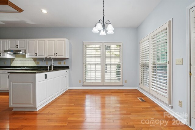 8731 Sheltonham Way, Charlotte, NC 28216 - kitchen with dark countertops, white cabinets, a chandelier, light wood-type flooring, and recessed lighting