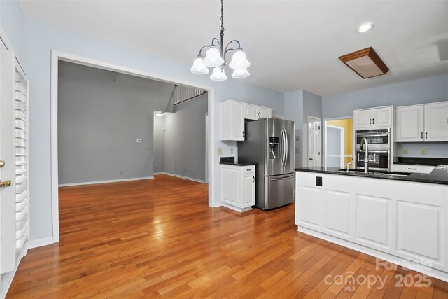 8731 Sheltonham Way, Charlotte, NC 28216 - kitchen featuring appliances with stainless steel finishes, dark countertops, light wood-type flooring, white cabinetry, and recessed lighting