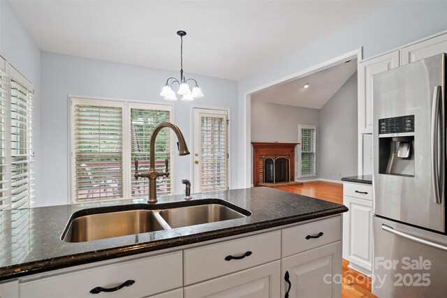 8731 Sheltonham Way, Charlotte, NC 28216 - kitchen with stainless steel fridge with ice dispenser, dark stone countertops, light wood-style floors, white cabinets, and lofted ceiling