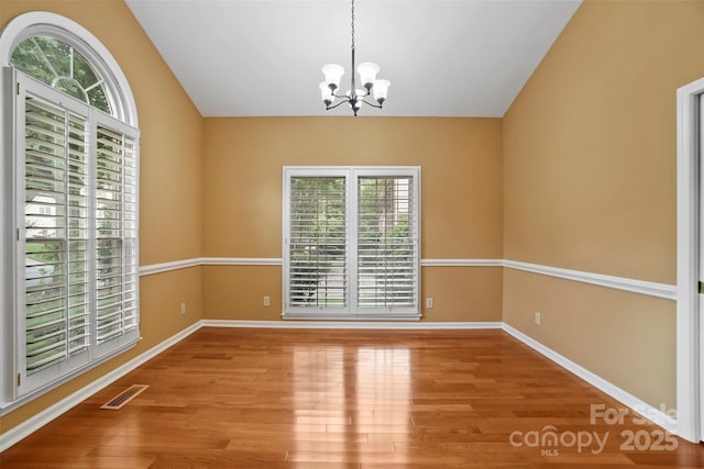 8731 Sheltonham Way, Charlotte, NC 28216 - unfurnished room featuring a chandelier, wood finished floors, and lofted ceiling