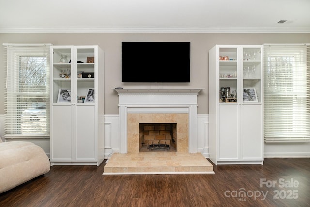 unfurnished living room with dark wood-style floors, a fireplace, and crown molding