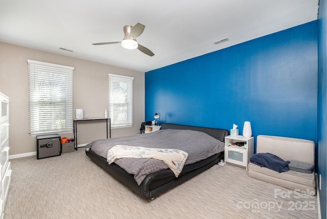 carpeted bedroom with visible vents, ceiling fan, and baseboards