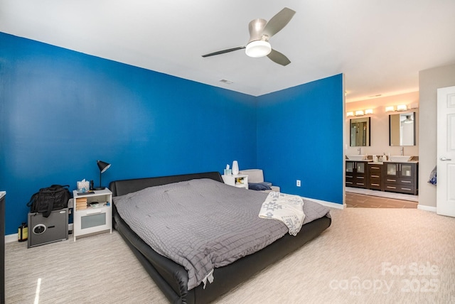 bedroom with ensuite bath, carpet, baseboards, and a ceiling fan