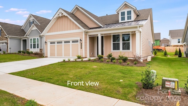 view of front of house with driveway, an attached garage, a standing seam roof, a front lawn, and board and batten siding