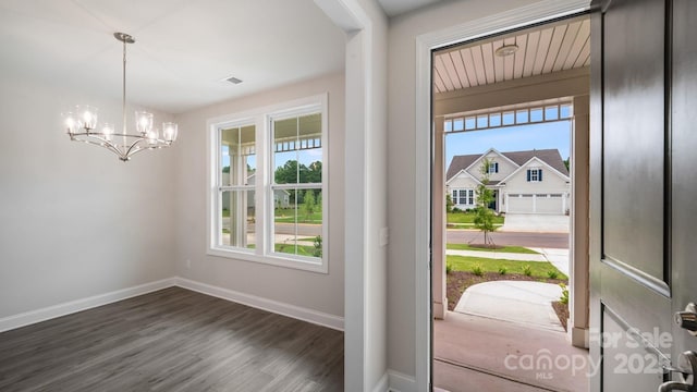 foyer featuring dark wood-type flooring, visible vents, baseboards, and an inviting chandelier