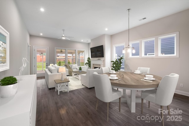 dining area with ceiling fan, recessed lighting, dark wood-type flooring, a fireplace, and visible vents