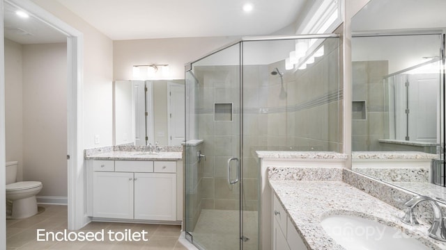 bathroom featuring toilet, tile patterned flooring, a shower stall, and a sink