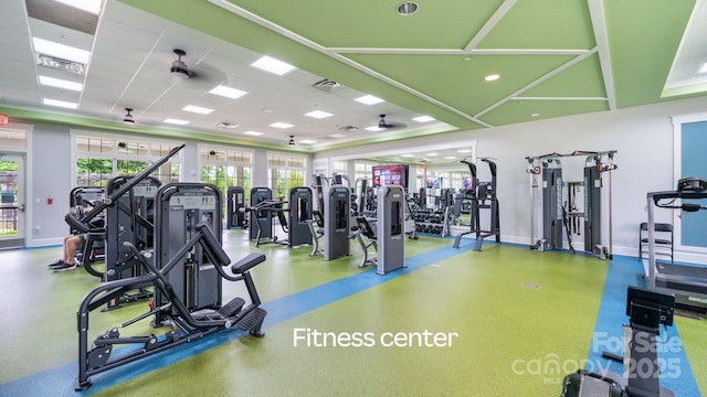 workout area with baseboards, visible vents, and a drop ceiling