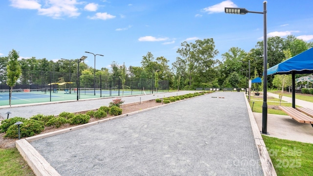 view of home's community featuring a tennis court and fence